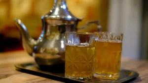 كوبا شاي متطابقان على صينية بجانب إبريق فضي في ضوء ذهبي دافئ يرمزان إلى لحظة هدوء مسائية بين الزوجين